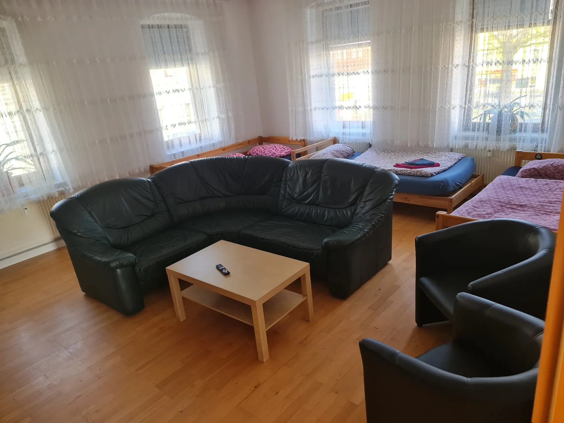 Wohnraum mit Ledersofa und Betten