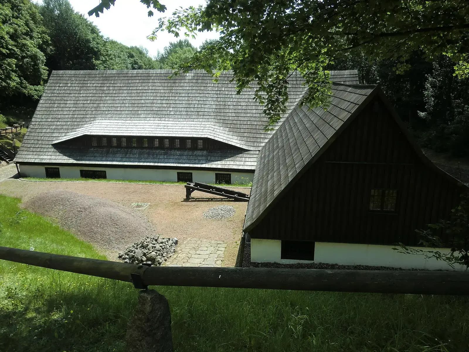 Das Gebäude des Bergbaumuseums Altenberg mit dunklem Schindeldach im Grünen