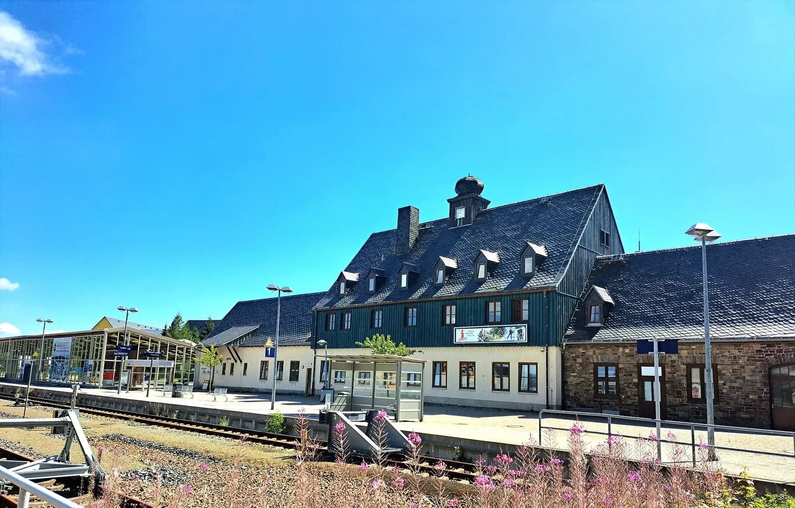 Empfangsgebäude des Bahnhofs Kurort Altenberg mit Bahnsteig im Sommer
