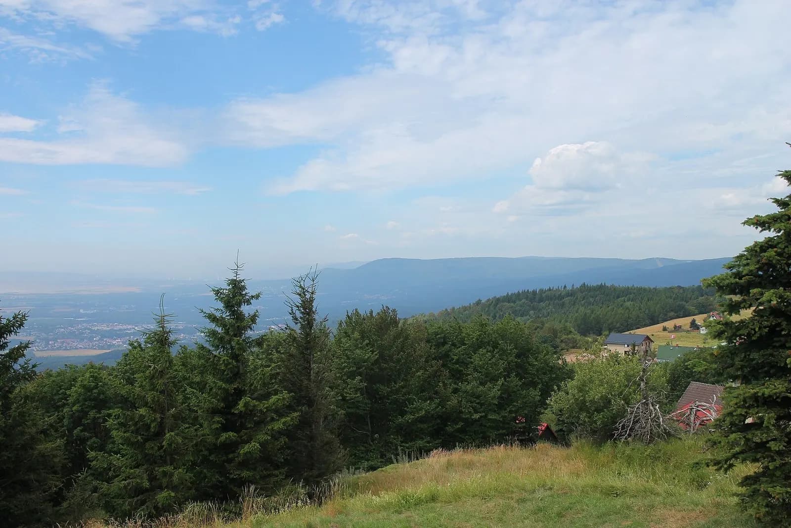 Blick vom Komáří vížka über bewaldete Hänge ins Nordböhmische Becken