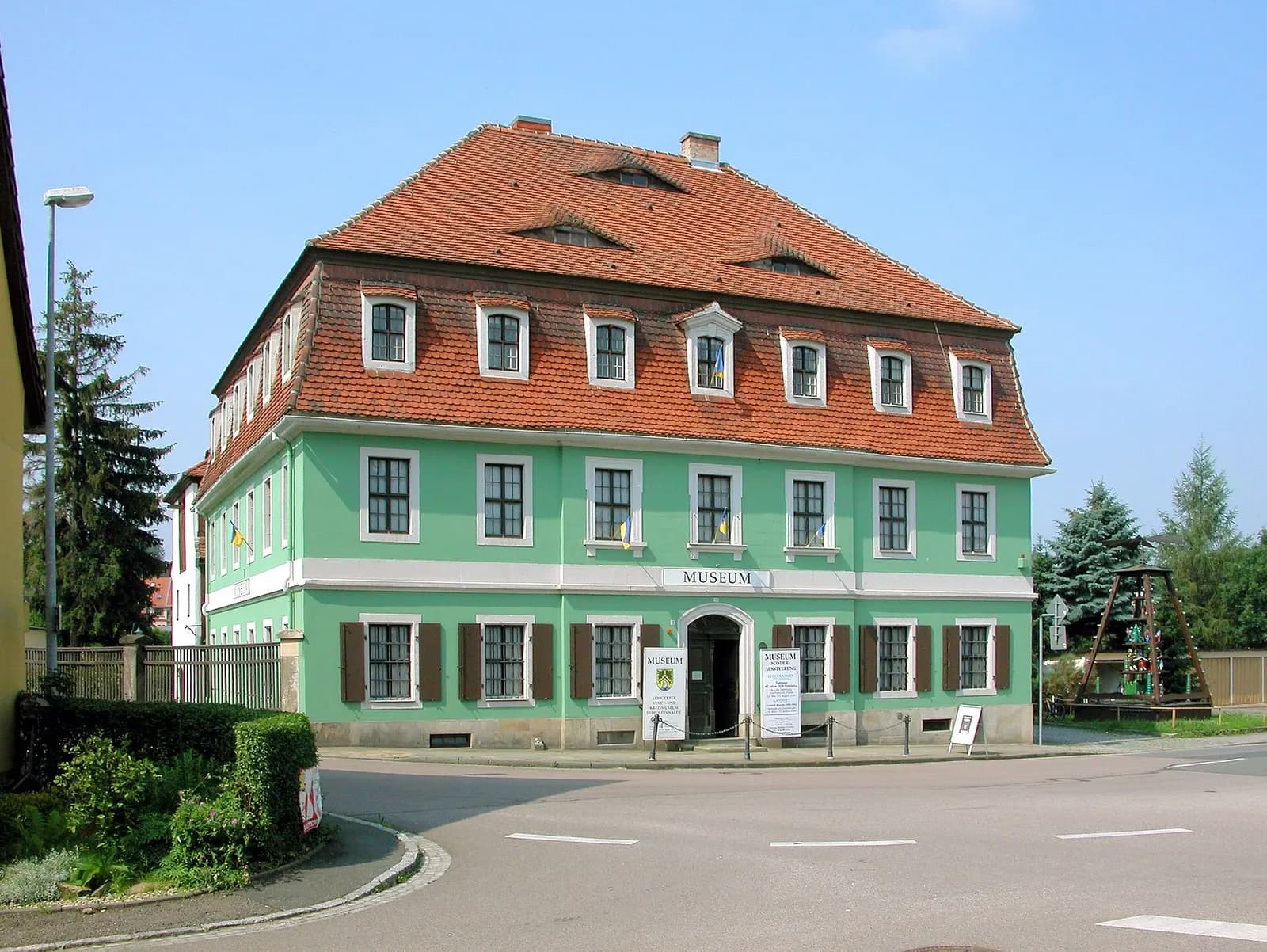 Barockes Gebäude des Lohgerber-Museums in Dippoldiswalde mit grüner Fassade, Mansarddach und Museumsschild