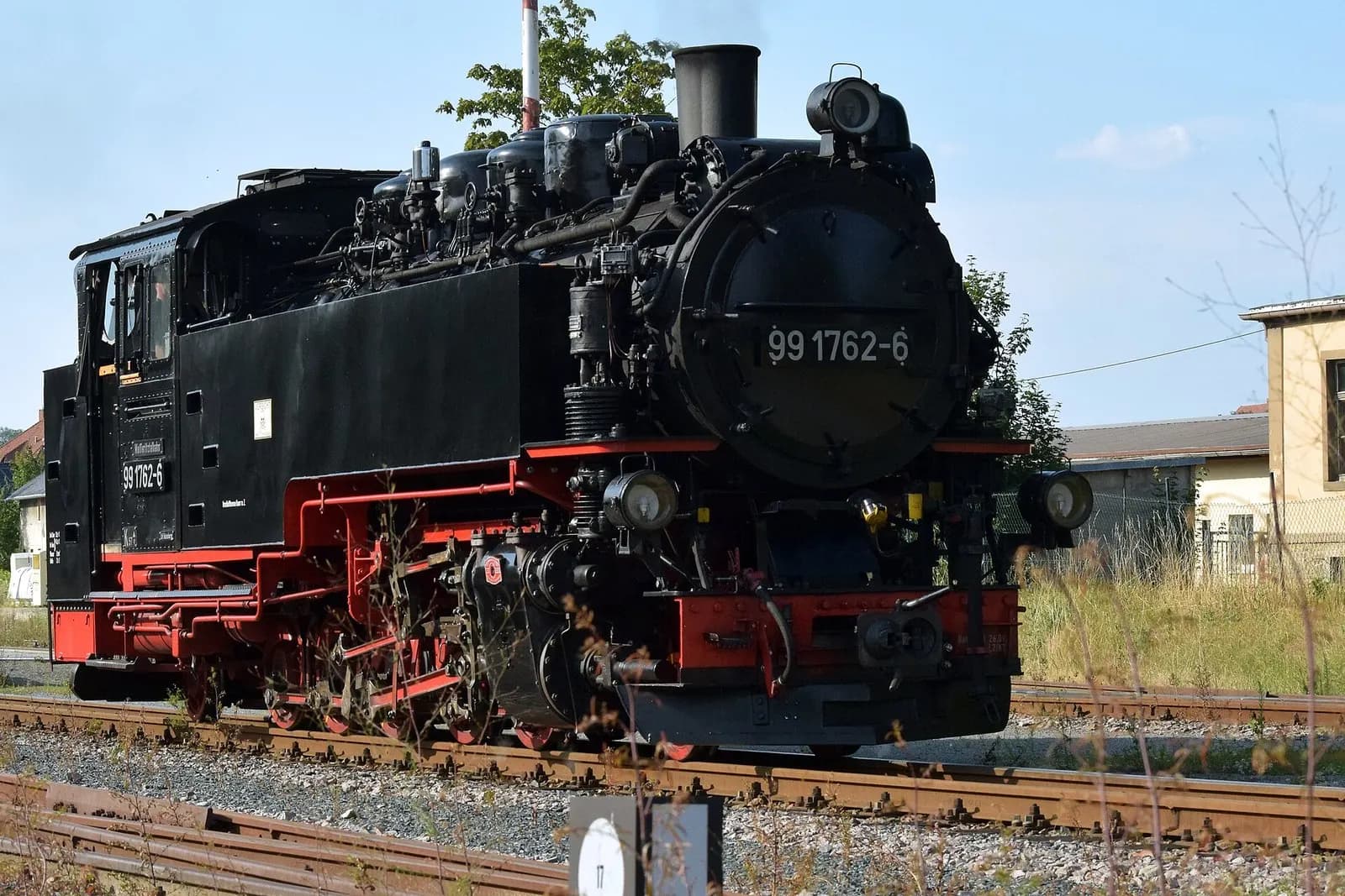 Schwarze Schmalspur-Dampflok 99 1762-6 mit roten Rädern im Bahnhof Dippoldiswalde