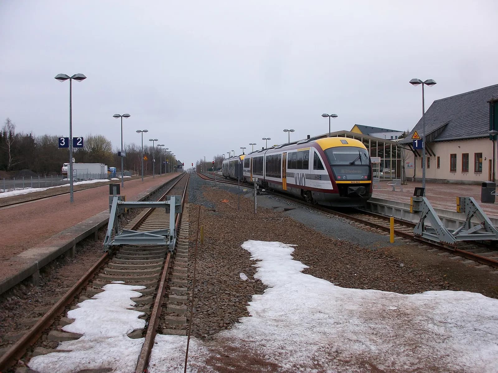 Bahnhof Kurort Altenberg mit einem Triebwagen nach Heidenau, Schneereste zwischen den Gleisen